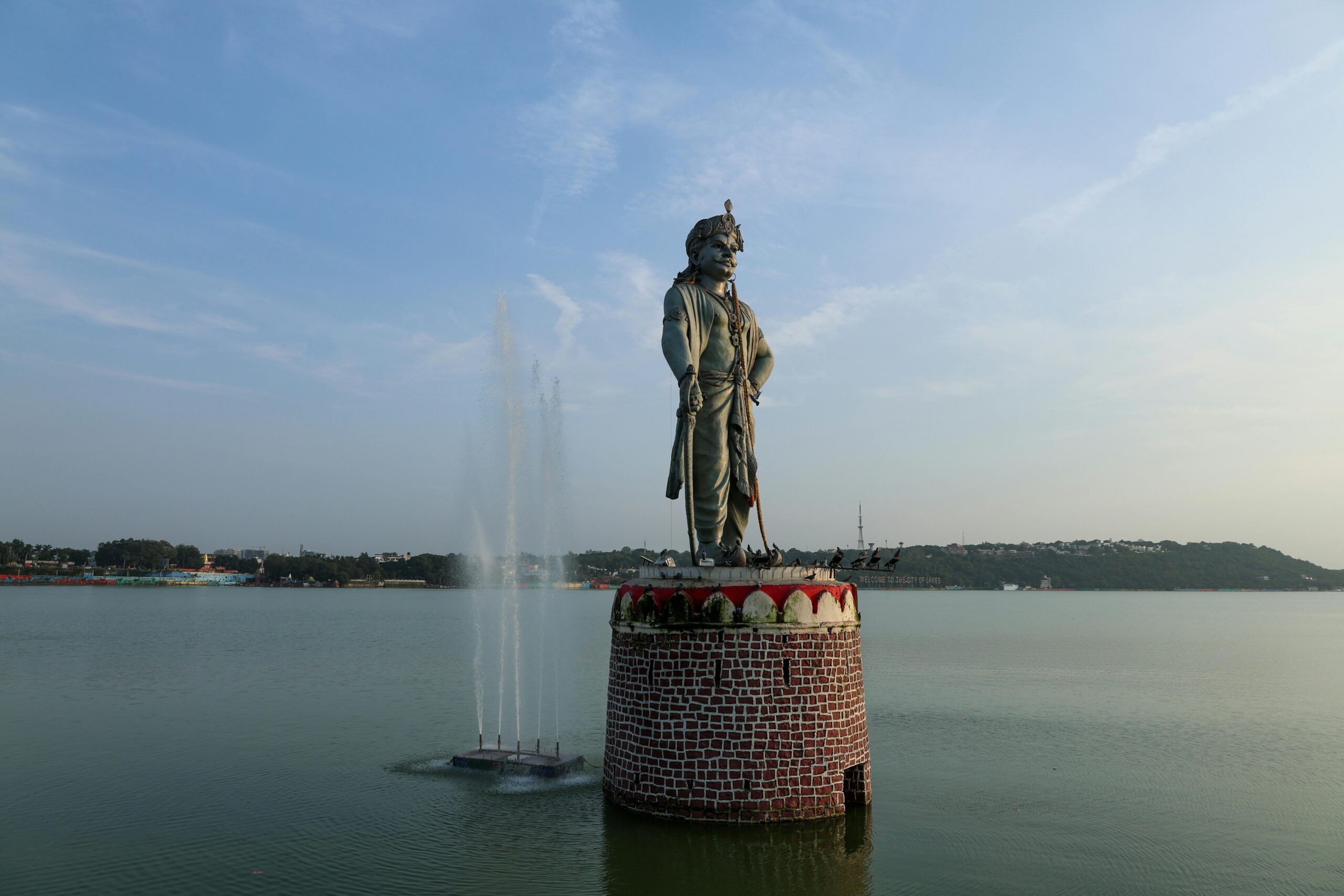 Raja Bhoj statue in Bhopal, India, standing tall in a serene lake view.