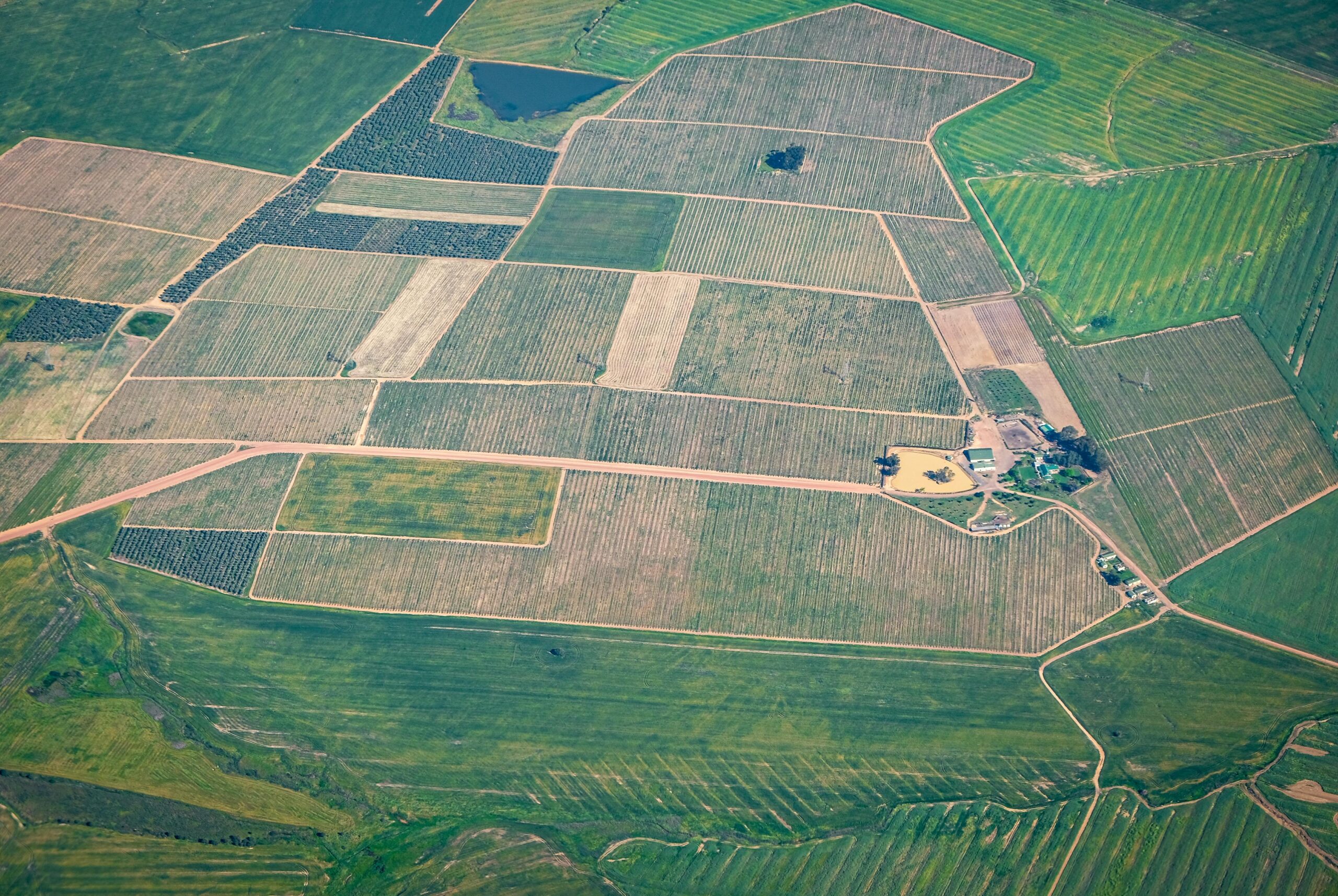 High-angle shot of vast agricultural lands with varying crop patterns in the countryside.